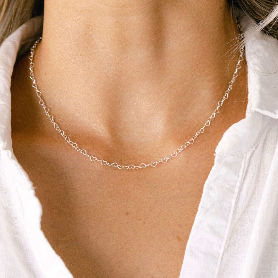 Silver heart necklace on a woman