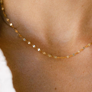 Gold chain necklace on a person's neck