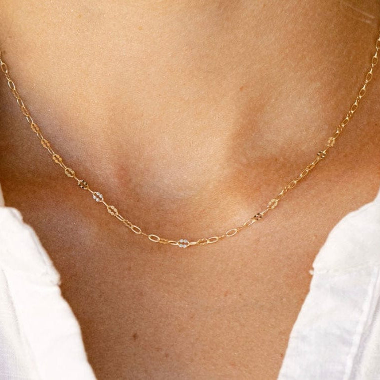 Gold chain necklace on white shirt