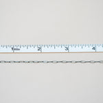 Metal chain with a ruler for scale on a light gray background