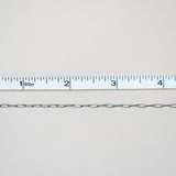 Metal chain with a ruler for scale on a light gray background