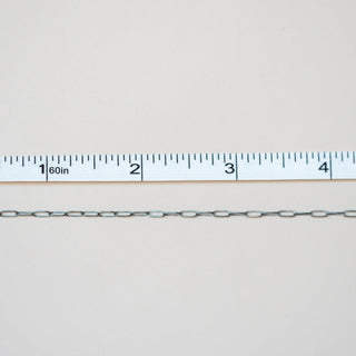 Metal chain with a ruler for scale on a light gray background