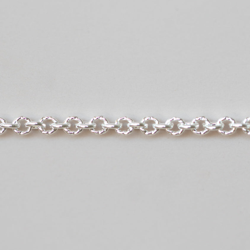 Silver chain bracelet on a light gray background