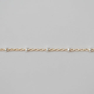 Gold chain bracelet on a light gray background