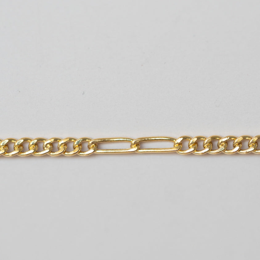 Gold chain on a light gray background