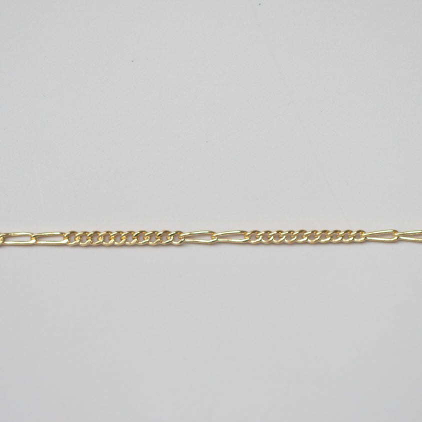 Gold chain on a light gray background