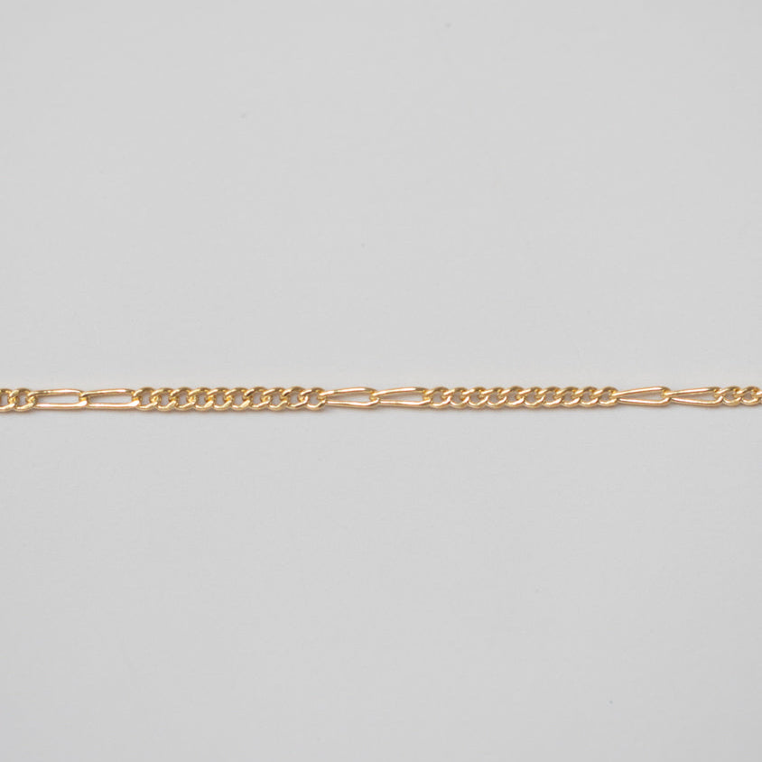 Gold chain on a light gray background