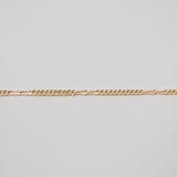 Gold chain on a light gray background