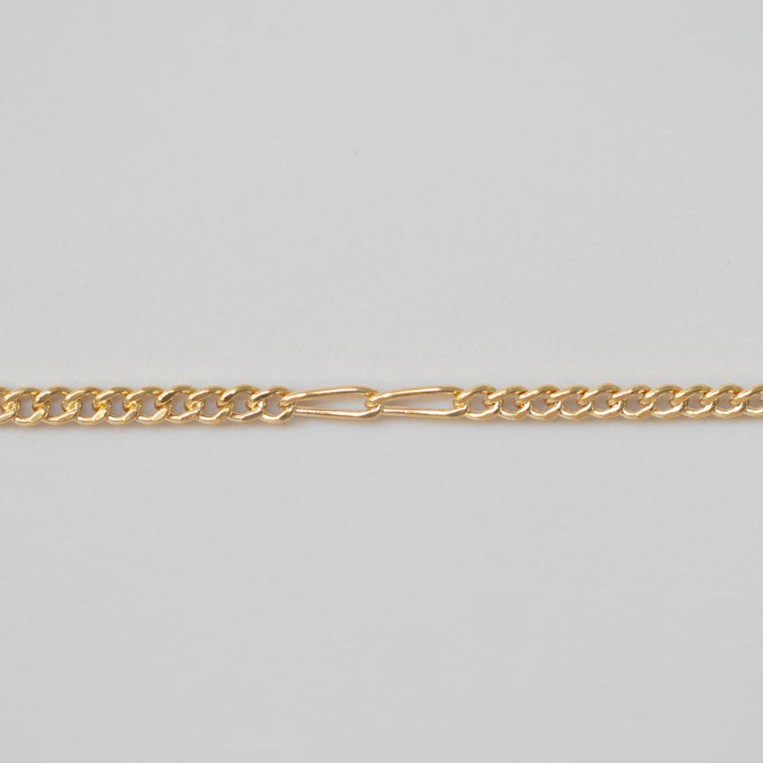 Gold chain on a light gray background