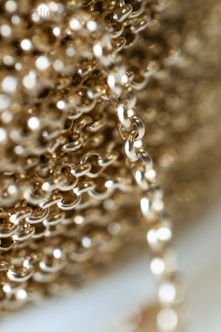 Close-up of a gold chain coiled on a spool.