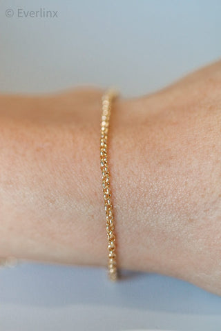 Gold beaded bracelet on wrist.
