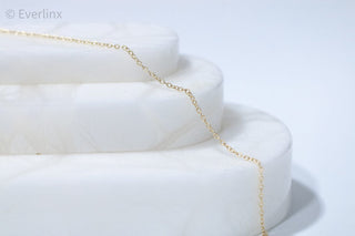 Gold chain necklace on white display